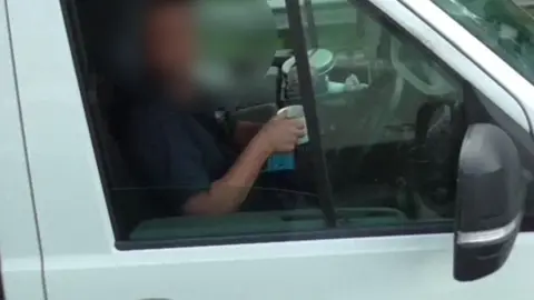 National Highways A driver drinking a cup of tea at the wheel on the M6