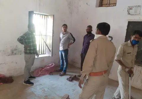 BBC Hindi Police inspect the broken window at a quarantine centre in Bulandshahar district in Uttar Pradesh from where 16 people escaped