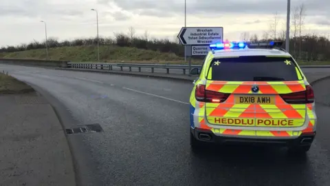 Police car entering site