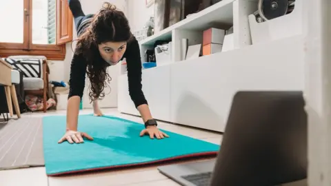 Getty Images Woman doing yoga online