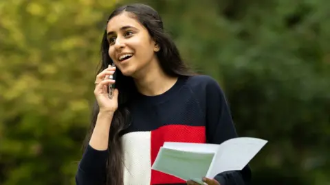 Getty Images Girl opening GCSE results making a call