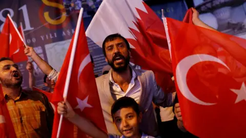 Reuters People shout slogans as they hold Turkish and Qatari flags during a demonstration in favour of Qatar in Istanbul, Turkey (7 June 2017)