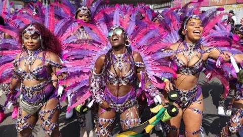 PA women in costume wearing pink and purple carnival costumes