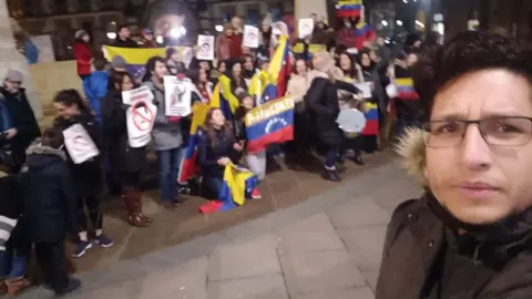 Adolfo Marquez Protest in Manchester about situation in Venezuela. People are holding flags and signs. 