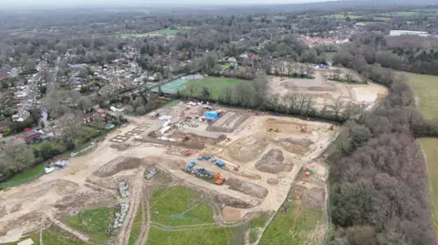 Peter Whittlesea/BBC A drone image of the Crawley Down Road development near Felbridge, Surrey. The site has been cleared for construction which is yet to begin.