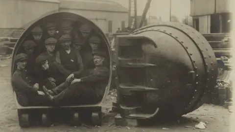 USMA Library Men inside one of the mud buckets from the Corozal dredger
