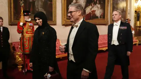 PA Media Lolwah Rashid Al Khater (L) and Keir Starmer (R) walking into the banquet