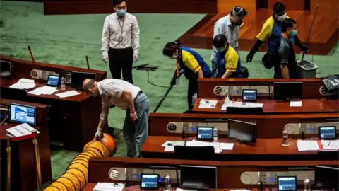 AFP Workers clean a section in the main chamber of the Legislative Council after lawmakers hurled a liquid during the third reading of the national anthem bill in Hong Kong on June 4, 2020