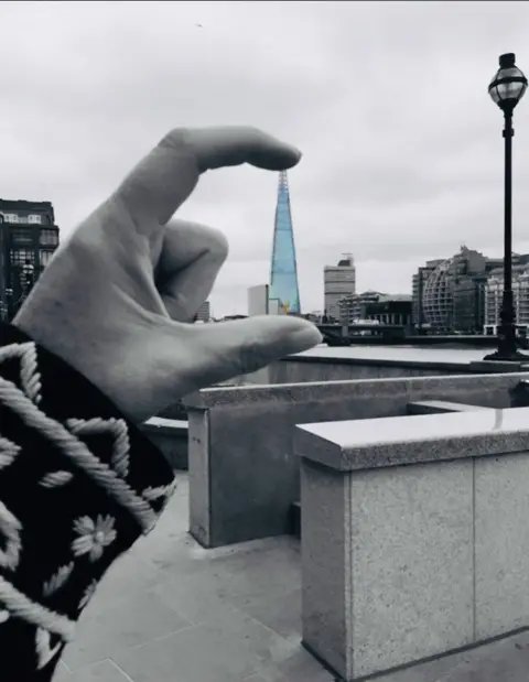 Linda Rowe Someone's thumb and forefinger surrounding the distant Shard building in London