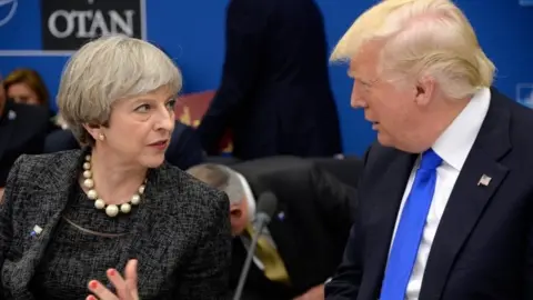 US President Donald Trump (R) speaks with British Prime Minister Theresa May during a working dinner meeting at the NATO summit in Brussels