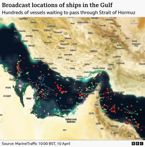 A satellite image of the Strait of Hormuz with ships marked with arrows. It shows hundreds of ships clustered by the strait waiting to pass. It is timestamped to 10:00 BST on 10 April