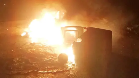 PSNI A bin set on fire in the north Belfast area, put out by the PSNI