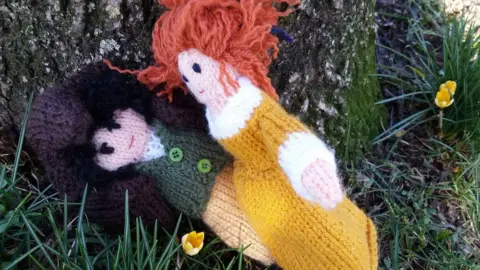 Kwerky Knits Knitted Ross and Demelza Poldark embracing at the base of a tree