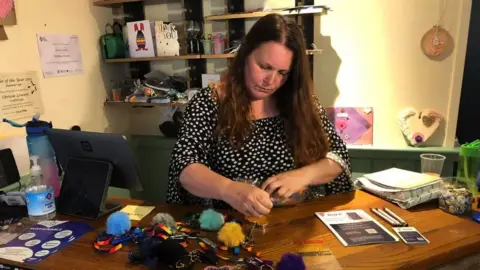 BBC Chrissie Lowery working in her craft shop.