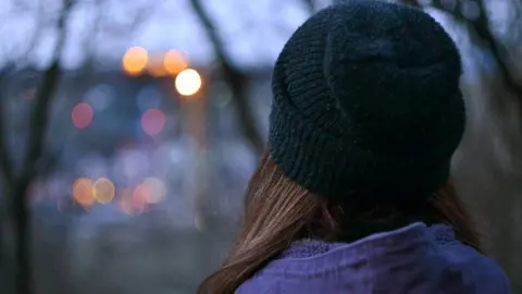 Getty Images Anonymous woman looking at city lights