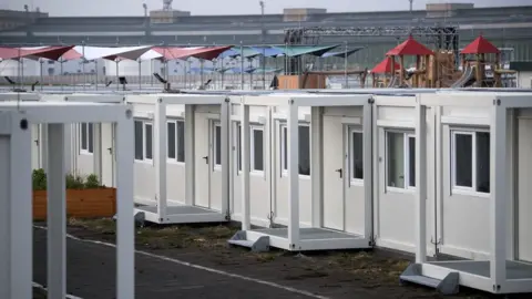 BERND VON JUTRCZENKA/AFP/Getty Images Container homes for asylum seekers are pictured at the Tempelhofer Feld former airport in Berlin, on 1 December, 2017.