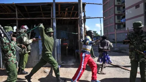 AFP An anti-riot policeman beats a man with a stick as police flushes out opposition supporters, who had taken cover in a shack to escape teargas, during demonstrations in the Umoja suburb of Nairobi on November 28, 2017, following a denial of permission by police to the National Super Alliance (NASA) leader to hold a rally concurrently to the inauguration of the country's new president.