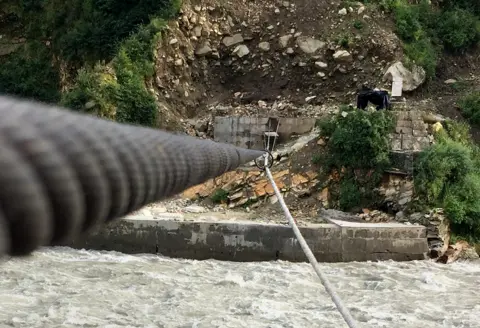 BBC The wires and cage across the river