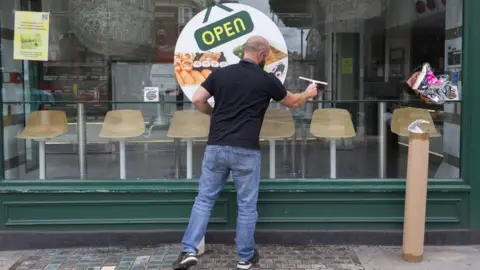 Getty Images Man cleans restaurant window