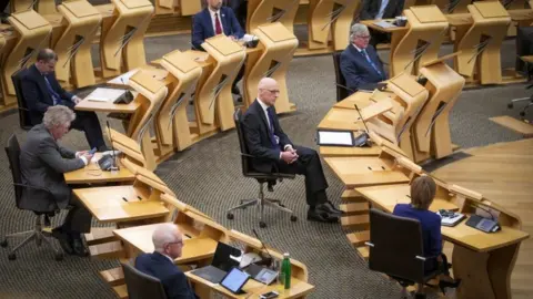 PA Media John Swinney at Holyrood