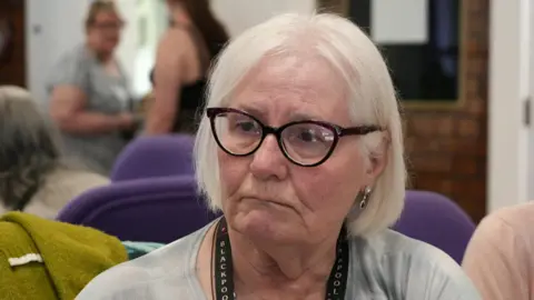 BBC/Nick Gemzoe Vera Skilbeck with grey hair and wearing glasses at one of the Trinity Network sessions.