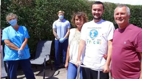 Swansea Bay University Health Board Callum with parents Tina and Keith Fleming, critical care physiotherapy team lead Karen James and physio technician Luke Thomas