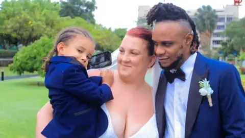 Family handout Lindsay Thompson in her wedding dress with her husband, Orlando, and their son, Arland