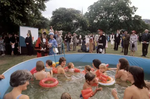 PA Media Queen Elizabeth II watches bathers in a pool at Parade Gardens, Bath, during her Silver Jubilee tour of Great Britain.