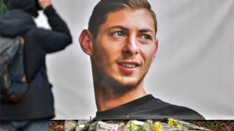 AFP/Getty Images Floral tributes in front of a poster of Emiliano Sala