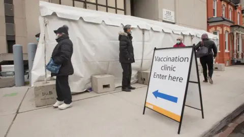 Getty Images People wait in the line outside the facility. UHN has a Vaccination Pilot injection site set up to administer the COVID-19 vaccine to those ear marked to receive it first.