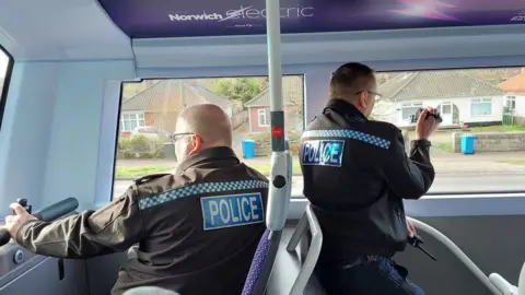 Norfolk Police Norfolk Police officers using video equipment on a bus