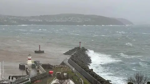 A grey and blustery view of Douglas Bay with choppy waters, with Onchan Head in the distance.