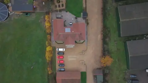 BBC An aerial view of David Drews home, showing the driveway to the right, where it should have been built.