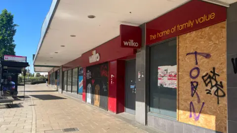 Owen Sennitt/BBC A department store with red branding for the company Wilko, with boarded up windows and doors. There is a white canopy over the pavement.