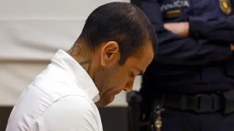 EPA Dani Alves sits in court with his head bowed during his trial