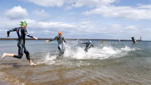 PA Media Participants enter the water at Roker for the swim leg of the triathlon events