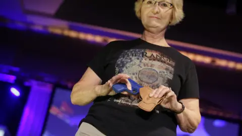 Getty Images A woman shows off a gun holster at an NRA fashion show