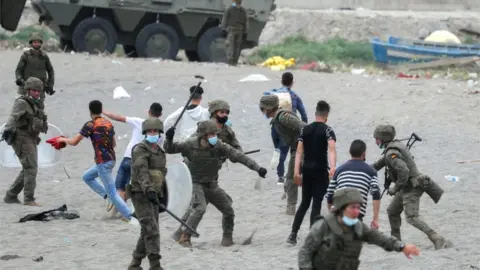 Reuters A Spanish soldier hits a Moroccan citizen at El Tarajal beach, near the fence between the Spanish-Moroccan border