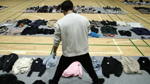 Getty Images Man looking through abandoned belongings in Seoul Gym.