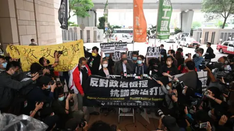 Getty Images Pro-democracy activists including former lawmaker Lee Cheuk-yan (C) rally at the courthouse - 16 April