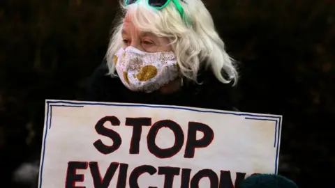 The Boston Globe via Getty Images A demonstrator carried a simple message. Boston tenants, faith leaders, and small landlords rallied and marched, calling for a stronger, longer federal eviction ban