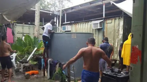 ABDUL AZIZ ADAM Asylum seekers and detainees at Manus Island around a water tank