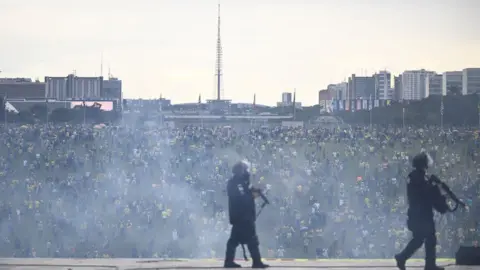 Getty Images Police gather as protesters riot in the background
