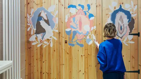 JACK LAWSON Oliwia Bober painting one of her vulva designs.