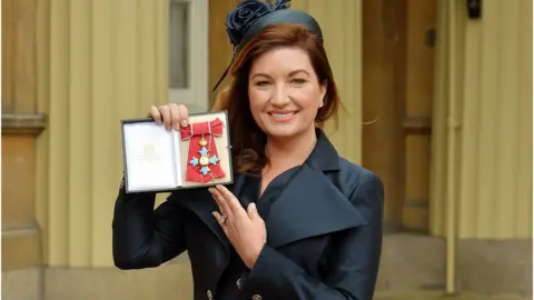 Getty Images Karren Brady holds her CBE (Commander of the Order of the British Empire) presented to her by the Duke of Cambridge at an Investiture ceremony at Buckingham Palace in central London on March 18, 2014.