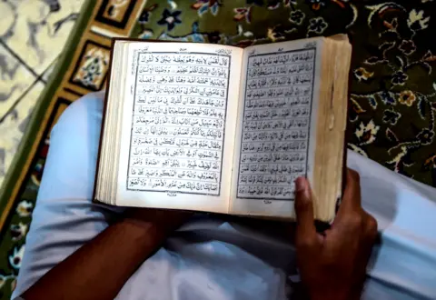 AFP A worshipper reads the Koran at his house