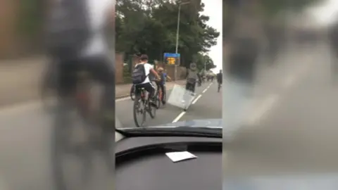 Group of cyclists in front of cars on North Road, Cardiff