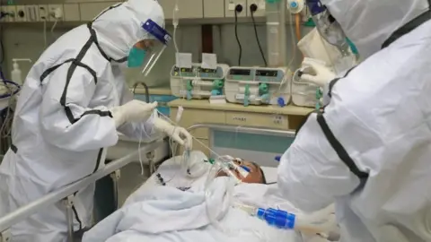 Reuters Medical staff treat a patient with pneumonia caused by the new coronavirus in Wuhan