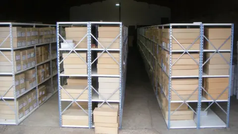 Albion Archaeology 3 storage racks full of boxes in a dimly lit room