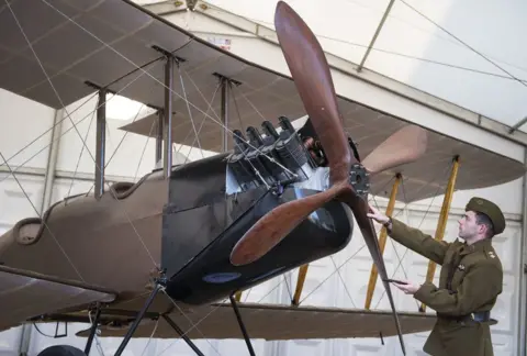 Victoria Jones/PA A re-enactor looks at a BE2c World War One bomber biplane on show at Horse Guards Parade in London as part of the National Aircraft Tour to mark 100 years of the Royal Air Force